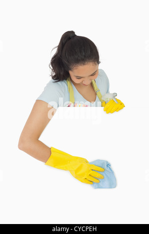 Donna sorridente in guanti bianchi pulizia di superficie Foto Stock