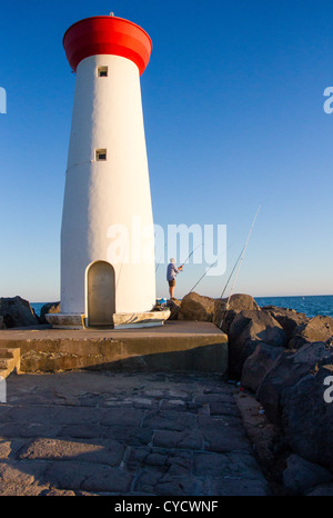 La pesca con il faro di Le Grau d Agde in corrispondenza della bocca di L'Herault fiume nel sud della Francia Foto Stock