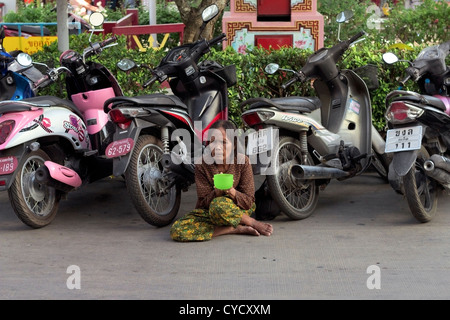 PHUKET, Thailandia Giugno 29 2012: donna anziana mendica per i soldi in un parcheggio presso un mercato all'aperto in Phuket, Tailandia. Foto Stock