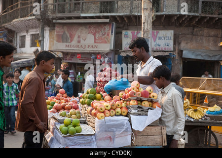 Uomo di mele di acquisto da un fornitore su strada spianata nella Vecchia Delhi - India Foto Stock