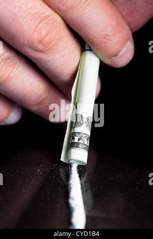 Mano azienda arrotolato nota alla linea di droga illegale Foto Stock