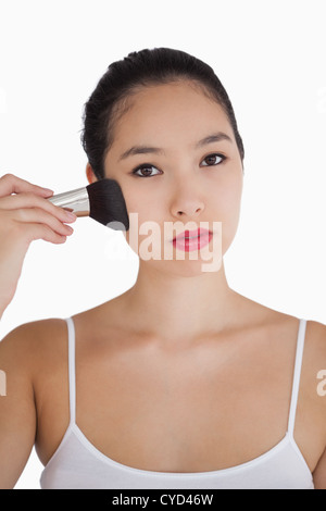 Donna l'applicazione di polvere alla faccia con spazzola Foto Stock