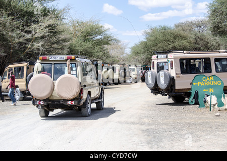 Safari veicoli rivestiti fino al parcheggio presso l'ingresso principale al Parco Nazionale di Tarangire e nel nord della Tanzania non lontano dal cratere di Ngorongoro e il Serengeti. Foto Stock