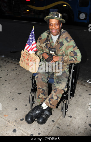 Senzatetto afro-americano di noi veterano seduto nella sedia a rotelle, per l'accattonaggio denaro, 7th Avenue, tra la 55th & 54th Street, New York Foto Stock