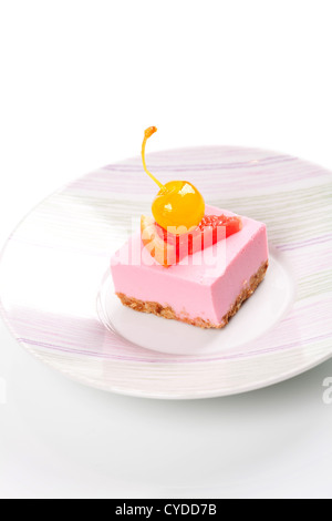 Rosa cheesecake con ciliegie al maraschino e pompelmo slice sulla piastra Foto Stock