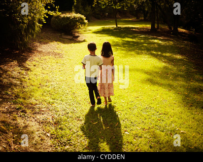 Ora d'oro: un ragazzo e una ragazza estate nel pomeriggio passeggiata nel bosco Foto Stock