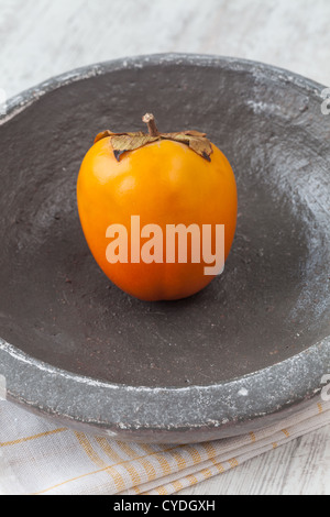 Fresche cachi grezzo in una lastra di pietra Foto Stock