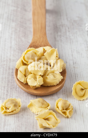 Mazzetto di tortellini freschi pasta sul cucchiaio di legno Foto Stock