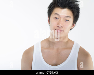Giovane bello muscolare maschio asiatici su sfondo bianco Foto Stock