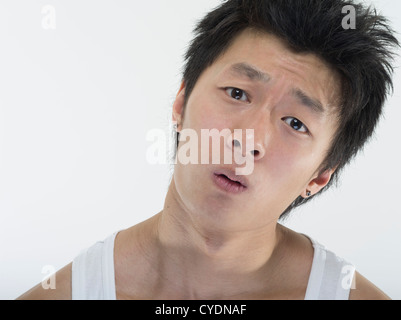 Dazed and Confused giovane uomo asiatico su sfondo bianco Foto Stock