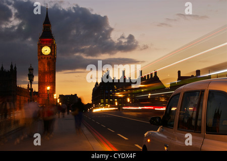 Come il mondo passa da un taxi si ferma sul Westminster Bridge accanto al case del Parlamento a Londra Foto Stock
