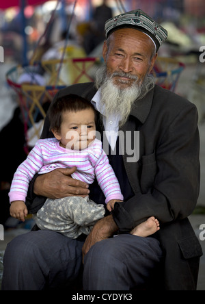 Il vecchio uomo uigura e Baby, Serik Buya Mercato, Yarkand, Xinjiang Uyghur Regione autonoma, Cina Foto Stock
