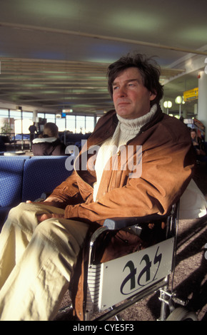 Preoccupato cercando disabilitato/uomo ferito in sedia a rotelle al lounge aeroportuale Foto Stock