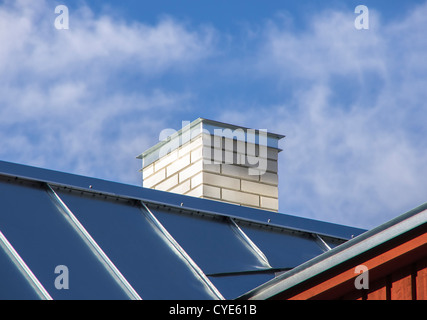 Nuovo metallo lucido con tetto bianco camino di mattoni Foto Stock