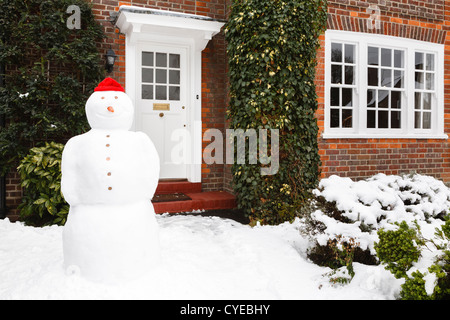 Pupazzo di neve nel giardino della casa in inverno Foto Stock