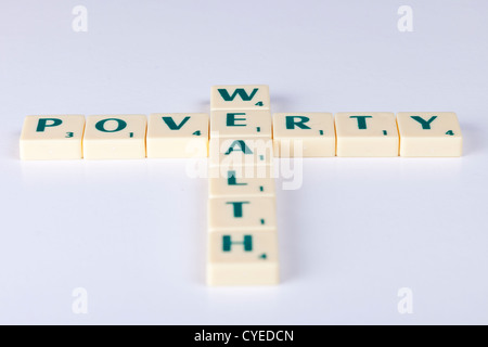 "Ricchezza povertà' enunciato mediante lettera di scrabble piastrelle a forma di croce. Foto Stock