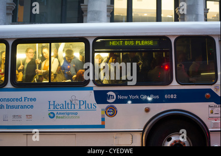 Pendolari in New York misurarsi con gli autobus affollati, il traffico e le linee lunghe sul loro viaggio home Foto Stock