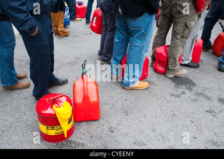 Linea di persone fino ad acquistare benzina a un Hess stazione di gas nel quartiere di Clinton di Manhattan a New York Foto Stock