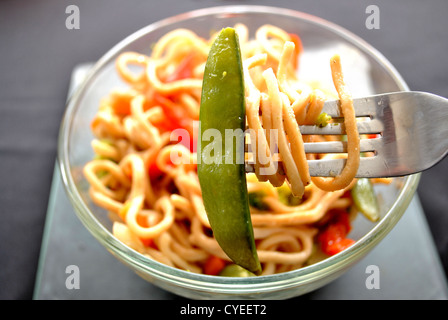 Lo Mein Tagliatelle con un Pea Pod su una forcella Foto Stock