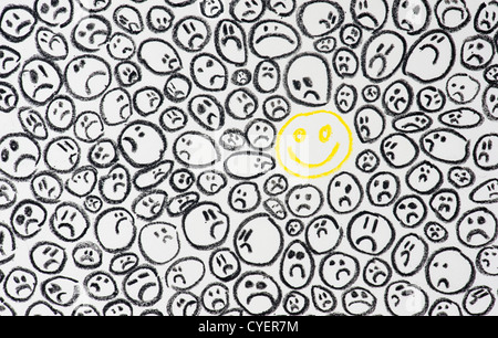 Pastello a cera di disegno di un felice volto sorridente tra buio facce tristi. Concetto di depressione Foto Stock