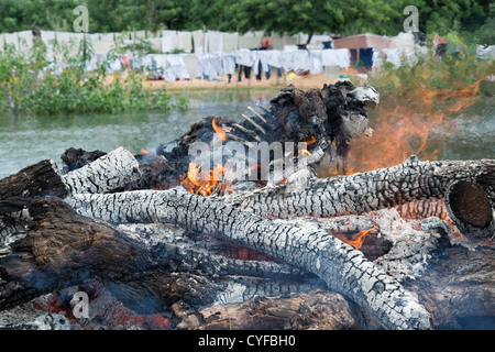 Cremating un corpo umano su un indù pira funeraria nesxt di un fiume. Andhra Pradesh, India Foto Stock