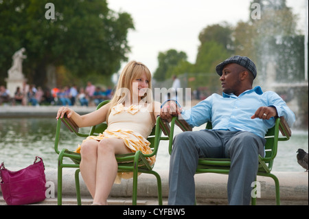 Parigi, Francia - Giovani razza mista giovane seduti su sedie a Jardin des Tuleries Foto Stock