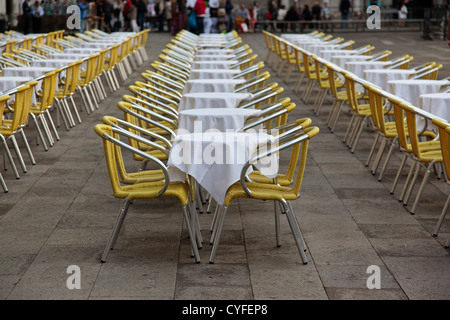 Le righe delle tabelle vuote e sedie al di fuori di un caffè di piazza San Marco, Venezia Foto Stock