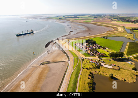 I Paesi Bassi, bagno, vista sul villaggio e sul fiume Westerschelde. Nave da carico. Antenna. Foto Stock