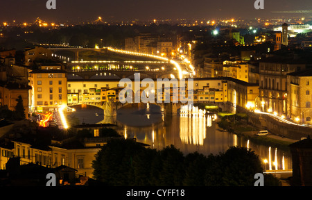 Vista notturna su Firenze in Italia con Ponte Vecchio (un ponte sul fiume Arno)nella parte anteriore Foto Stock