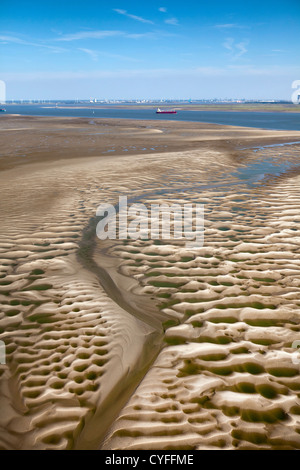 I Paesi Bassi, Nieuw Namen, nave da carico nel fiume Westerschelde. Area industriale di Anversa. Primo piano sandbank di marea. Antenna. Foto Stock