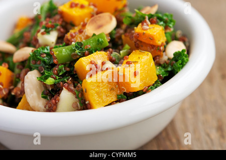 Un caldo con insalata di quinoa rossa, fagiolini, squash, kale, apple e mandorle. Foto Stock