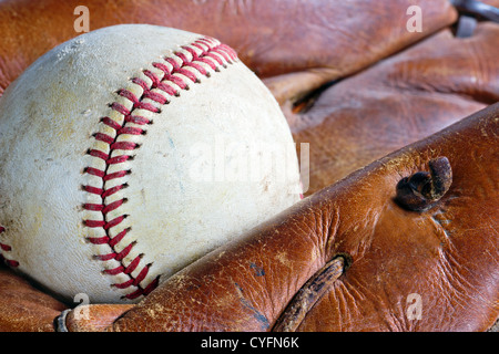 Primo piano della vecchia e weathered baseball guanto in pelle e la sfera Foto Stock