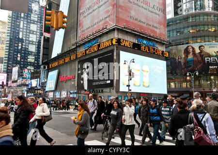 La folla ritorno a Times Square a New York City il Venerdì 2 Novembre, 2012, ma Sandy è ancora sulla illuminata Dow Jones News ticker.gran parte della città sotto 34th Street rimane senza alimentazione in questo momento. Foto Stock