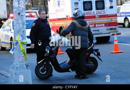 Nov. 3, 2012 - Manhattan, New York, Stati Uniti - Un ufficiale di polizia ordina uno scooter pilota al di fuori dell'sono dopo il taglio della linea come i newyorkesi linea 10th Avenue in attesa di combustibile a LukOil gas station a 24th Street nel Quartiere di Chelsea in seguito gli effetti dell'Uragano Sandy in New York, 3 novembre 2012. (Credito Immagine: © Bryan Smith/ZUMAPRESS.com) Foto Stock