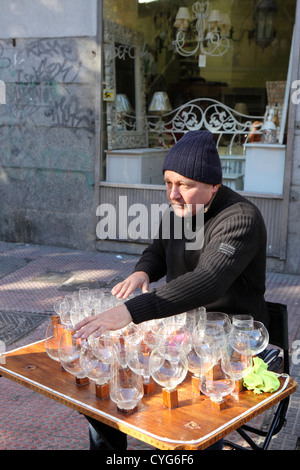 Uomo di mezza età di riproduzione di musica sull'arpa di vetro bicchieri di vino con quantità di acqua il mercato di El Rastro Madrid Spagna Europa Foto Stock