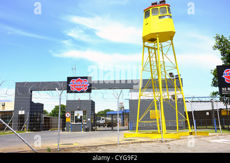 Un giallo di protezione/torre di guardia dietro reticolati di filo spinato. Foto Stock