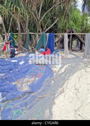 I pescatori riassettavano le reti di Nungwi un piccolo paese di pescatori con spiagge di sabbia bianca sulla punta nord di Zanzibar;Tanzania;l'Africa Foto Stock