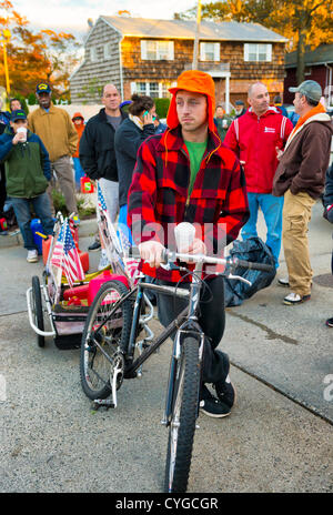 Nov. 3, 2012 - Merrick, New York, Stati Uniti - JOHN GIBSON (indossando orange hat), di Merrick, usato una bicicletta carrello per portare il gas di contenitori da riempire a Hess, uno di Long Island le stazioni di gas ancora aperta il sabato dopo l uragano Sandy martoriata questa south shore. Foto Stock