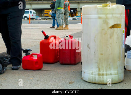 Nov. 3, 2012 - Merrick, New York, Stati Uniti - Persone attendere in linea nel freddo crepuscolo per riempire i contenitori di gas al Merrick Hess stazione, uno di Long Island le stazioni di gas ancora aperta il sabato dopo l uragano Sandy portato gravi danni per questo south shore. Stati Uniti Esercito la Guardia Nazionale di membri da Siracusa sono lì per aiutare a Nassau County polizia assicurarsi che l'ordine è mantenuto. Foto Stock