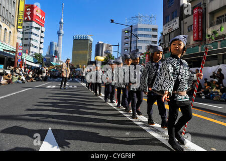 Novembre 3rd, 2012 : Tokyo, Giappone - i bambini hanno marciato come una parte di prestazioni di Tokyo Jidai Matsuri, o a Tokyo il corteo storico, come Tokyo Sky Tree è stato visto dietro al Tempio di Asakusa, Taito, Tokyo, Giappone il 3 novembre 2012. È stato il ventiquattresimo festival annuale, e circa 1200 gli artisti interpreti o esecutori hanno marciato per le strade della città secondo il caso delle autorità. (Foto da Koichiro Suzuki/AFLO) Foto Stock