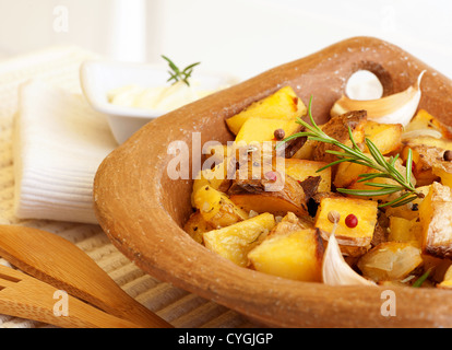Foto di saporite patate fritte con aglio, verdure cotte, patatine fritte, verdure alla griglia nel piatto di legno sul tavolo Foto Stock