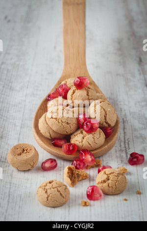 Croccanti amaretti italiani con rosso fresco di grani di melograno Foto Stock