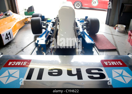 Una shell classica sponsorizzato auto di Formula Uno seduto in un garage prima di una gara. Foto Stock