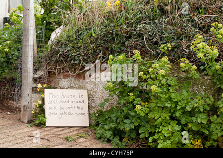 Happisburgh. Beach Road. Home non ancora liberato. Rassegnati residenti scritto a mano segno da gate. Residenza successivo per essere demolita. Foto Stock