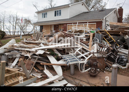 Nov. 4, 2012. I residenti di Tottenville sezione di Staten Island pila detriti dalle loro case danneggiate in strada. Foto Stock