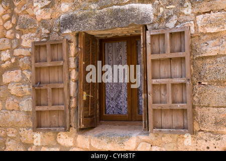 Vecchio eooden incorniciata e la finestra ritagliata nel muro di pietra, Siurana, Catalunya, Spagna Foto Stock