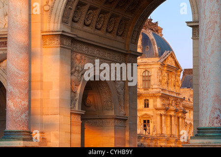 Impostazione della luce solare sullo Arco di Trionfo du Carrousel con il Musee du Louvre al di là, Parigi, Ile-de-France, Francia Foto Stock