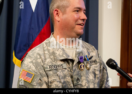 Il personale sergente Patrick Rogers parla ai media dopo aver ricevuto il cuore viola dal governatore del Texas Rick Perry in Austin Foto Stock