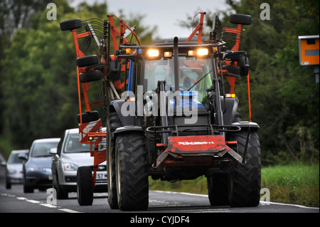 Vetture bloccato dietro un trattore su una strada nel GLOUCESTERSHIRE REGNO UNITO Foto Stock