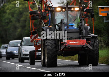 Vetture bloccato dietro un trattore su una strada nel GLOUCESTERSHIRE REGNO UNITO Foto Stock